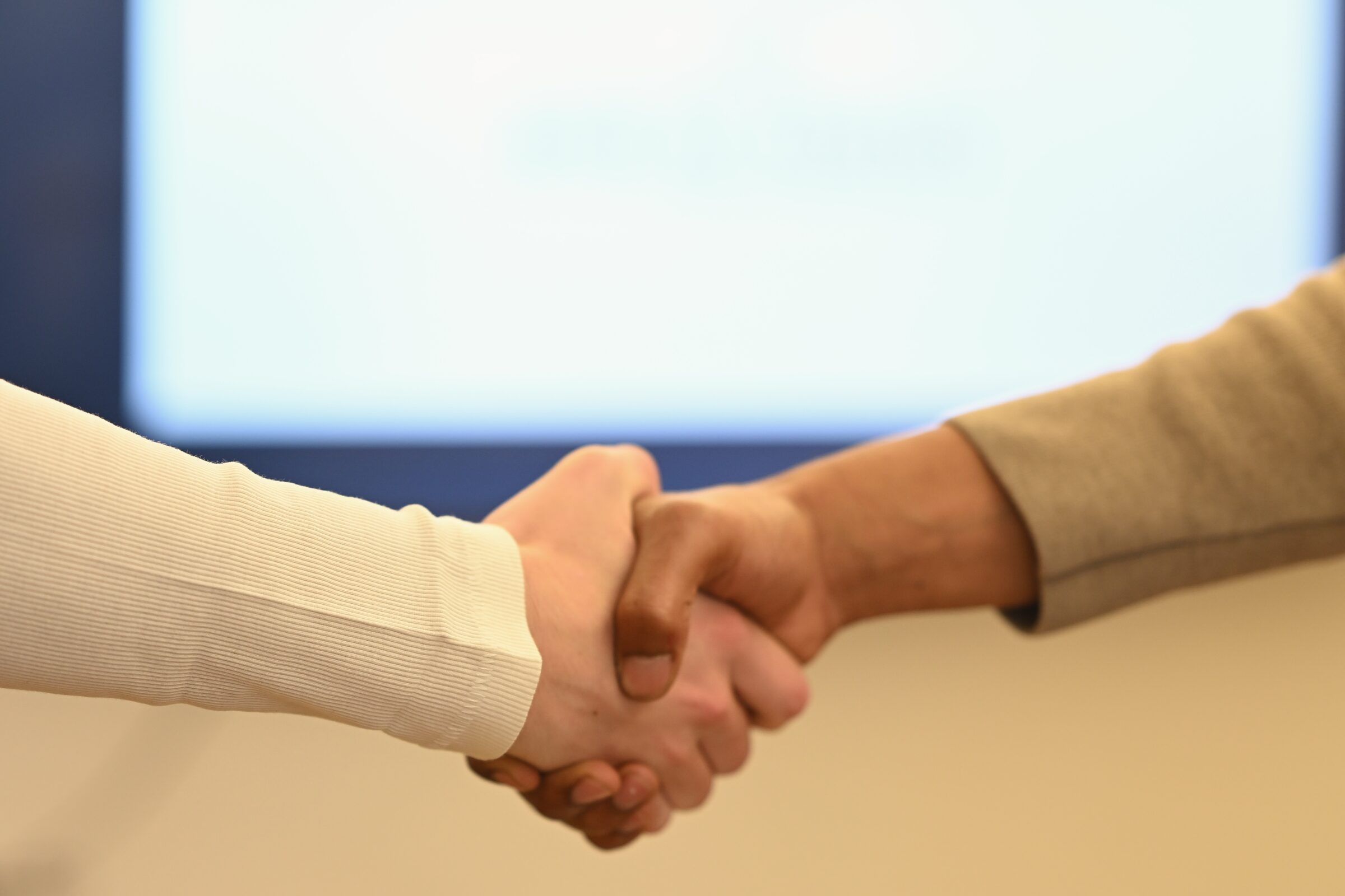 Handshake in front of a blurred screen
