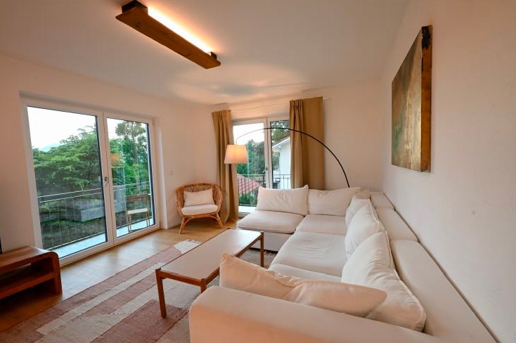 Wohnzimmer einer Liboria-Ferienwohnung mit Panoramatüren und Balkon